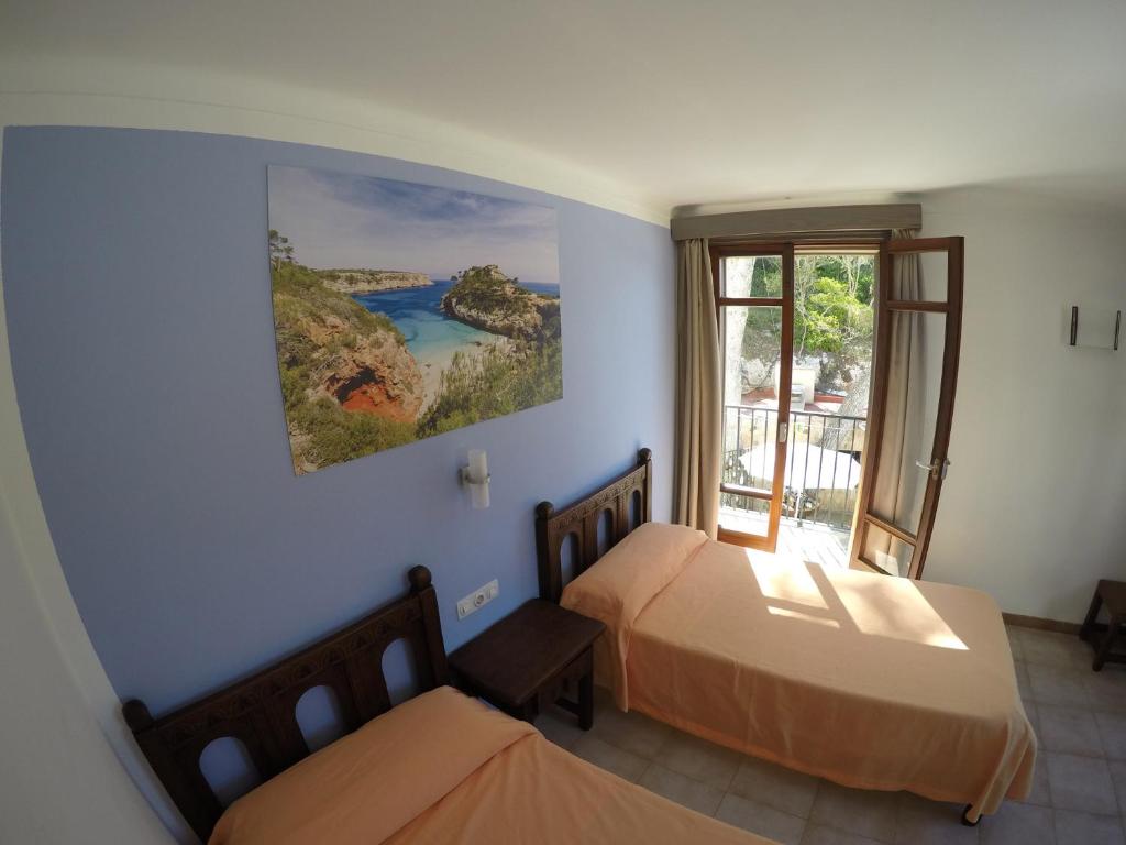 卡拉桑塔尼Hostal Playa的一间卧室设有两张床和窗户。