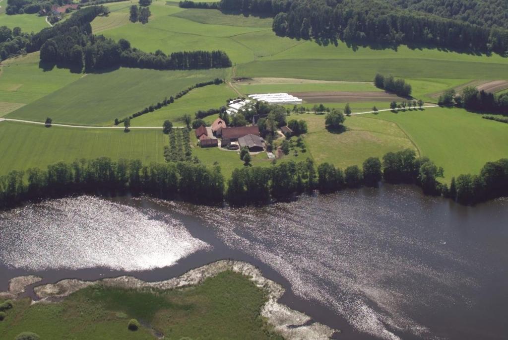 Rösslerhof Ferienwohnung Stiller Bach的享有湖畔房屋的空中景致