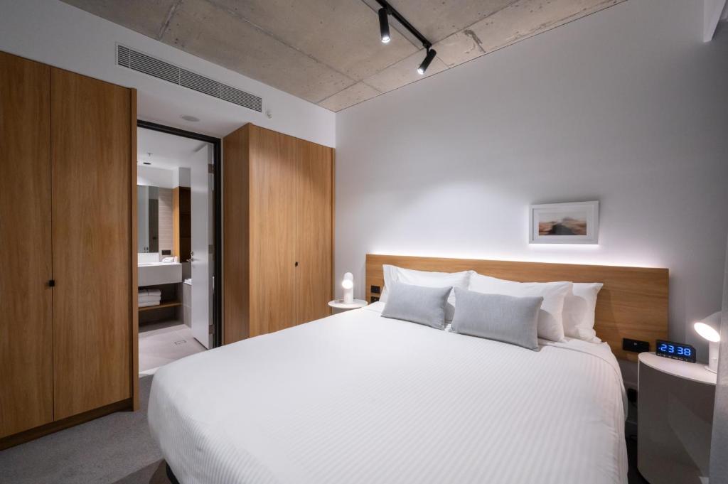 墨尔本Nesuto Docklands的卧室里有一张白色的大床，配有白色的枕头