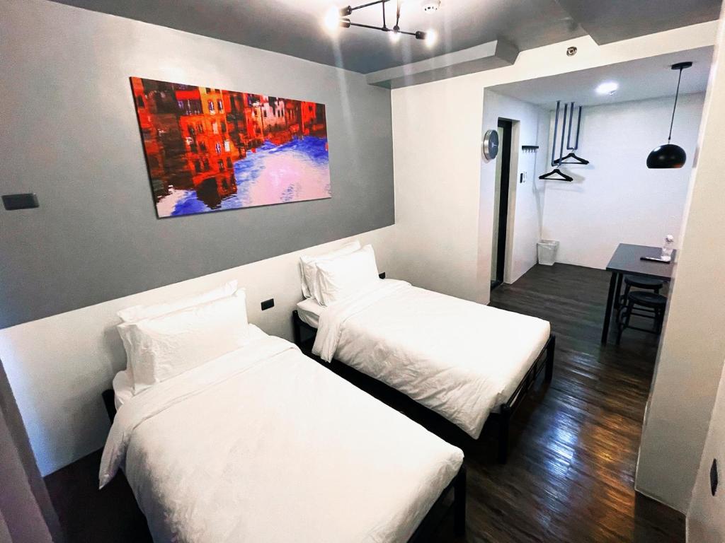 马尼拉mySTAY Hotel BGC North的墙上画画的房间里设有两张床