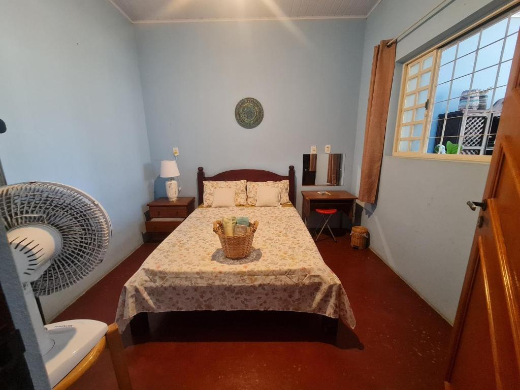 戈亚斯MAEVE Quarto Mata的一间卧室配有一张带桌子和窗户的床