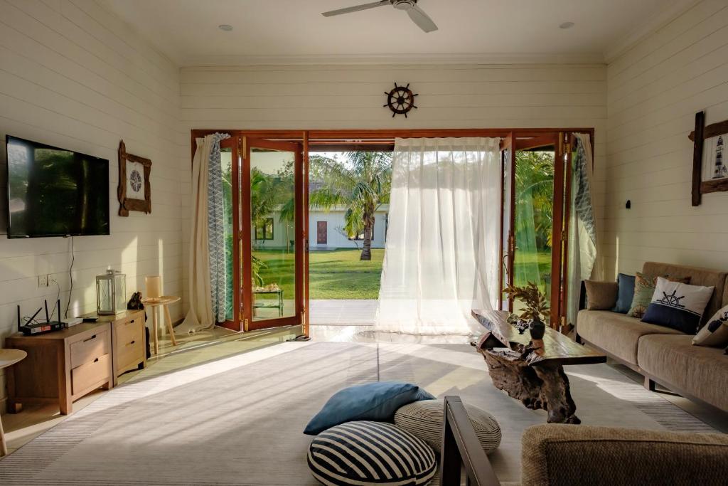 巴东马士力Sembilan Langkawi的带沙发和滑动玻璃门的客厅