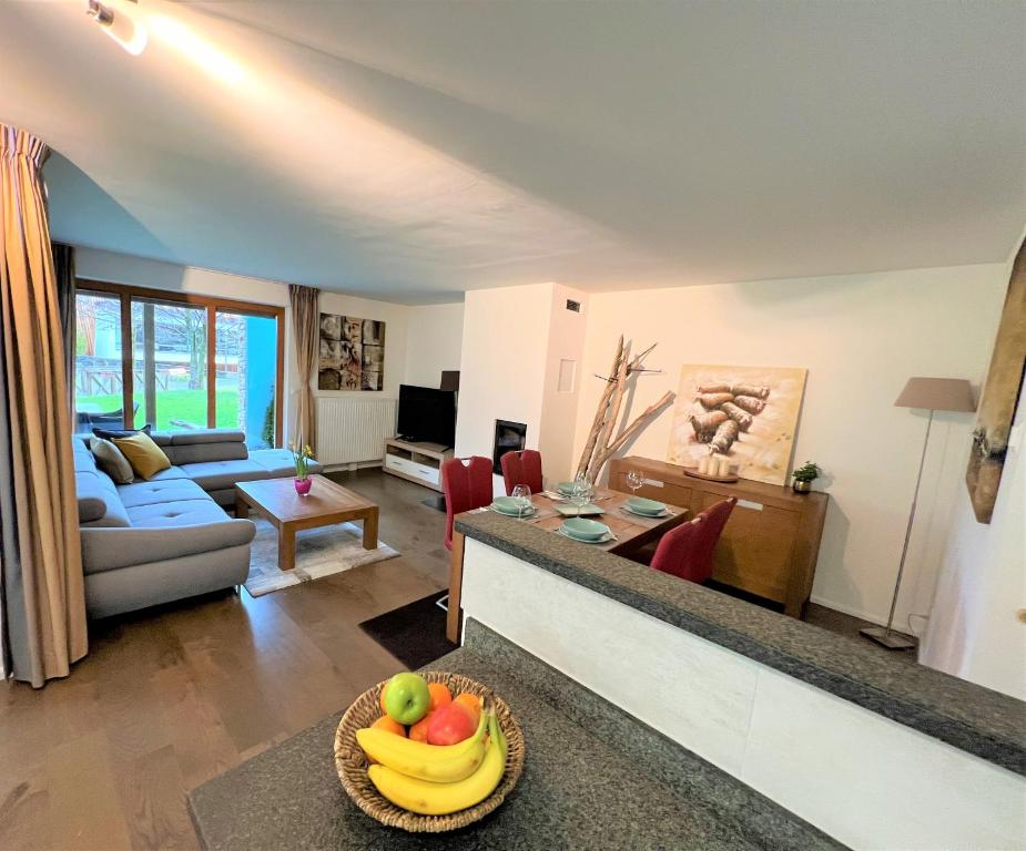安特特泽Walensee Apartment, Lakeside Dream的客厅配有沙发和带一碗水果的桌子