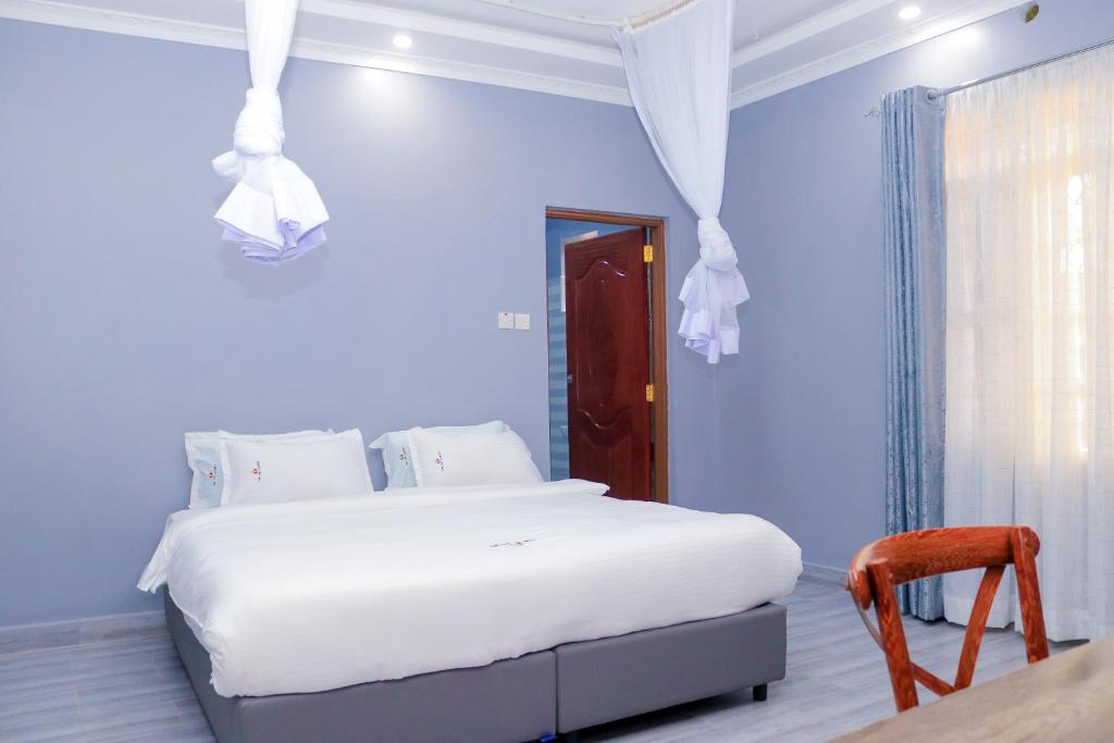 基苏木The VIP Luxury Lounge Hotel的卧室配有白色的床和椅子