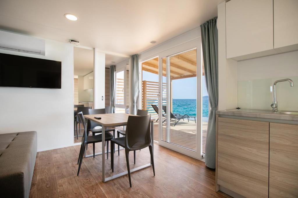 希贝尼克Deluxe Beach Mobile Homes的一间厨房、带桌椅的海景用餐室