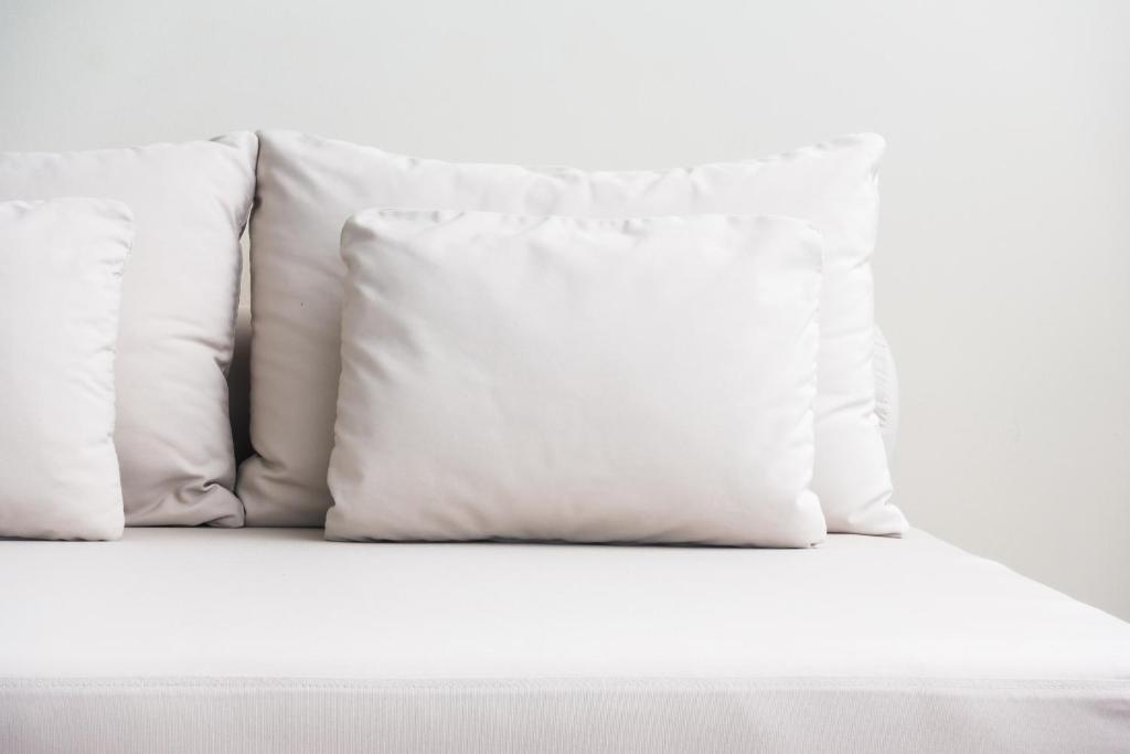 卢森堡Core Luxembourg City的床上的一堆白色枕头