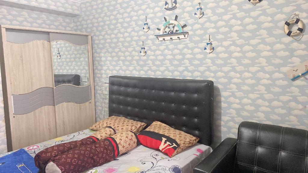 万隆INPRO Apartment的一间卧室配有一张带黑色皮革床头板的床