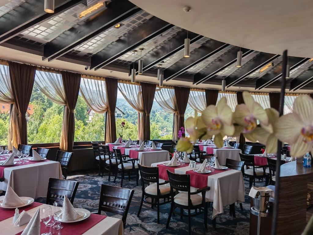 布拉索夫贝尔福德雷尔酒店的用餐室设有桌椅和窗户。