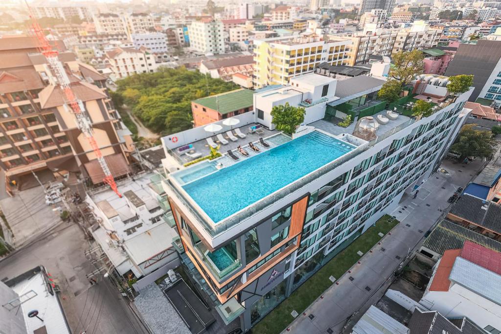 芭堤雅市中心Amethyst Hotel Pattaya的享有带游泳池的大楼的顶部景致