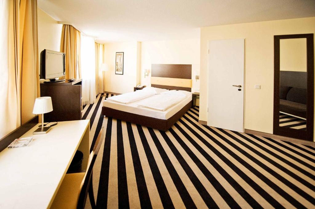 美因河畔法兰克福Bristol Hotel - Frankfurt City的酒店客房,配有床和电视