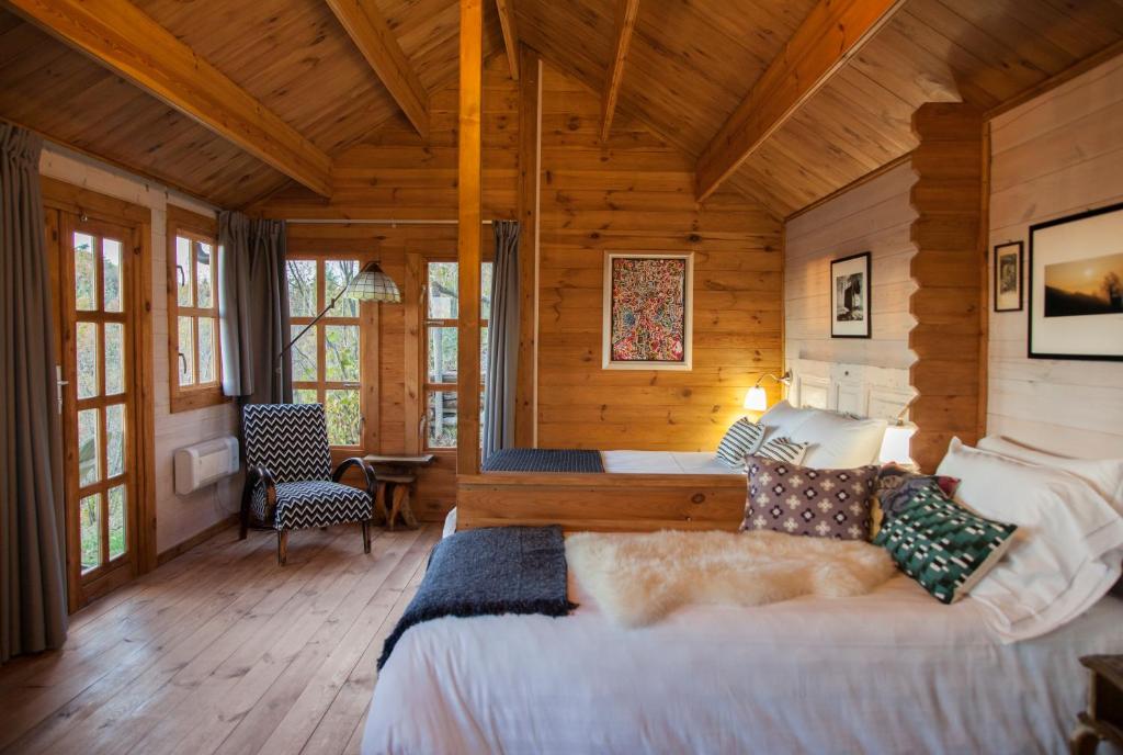 博古梅尔Pian Del Mund的木制客房内的一间卧室配有一张大床