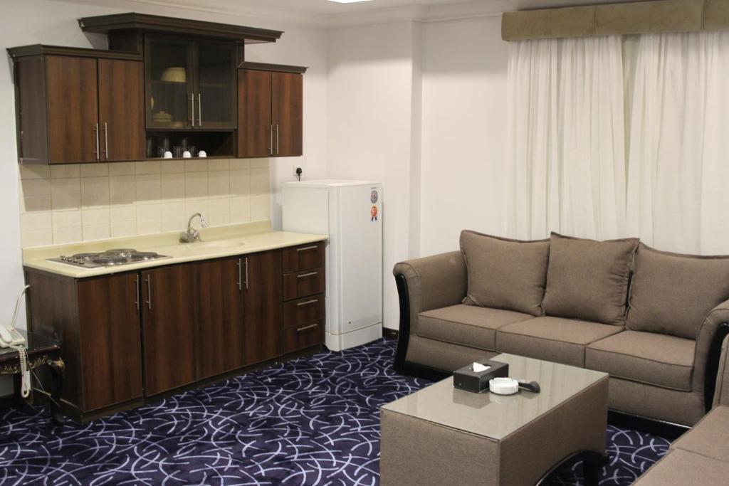 利雅德Carawan Al Khaleej Hotel Olaya的带沙发的客厅和厨房