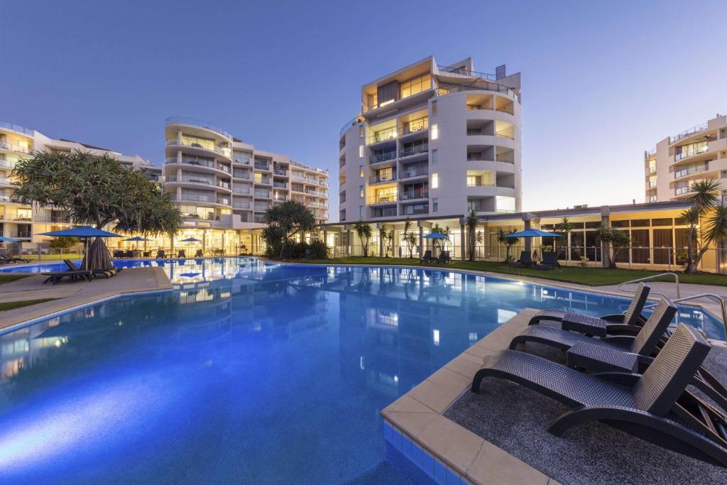 马库拉马库拉海滩华美达酒店的一座带椅子和建筑的大型游泳池