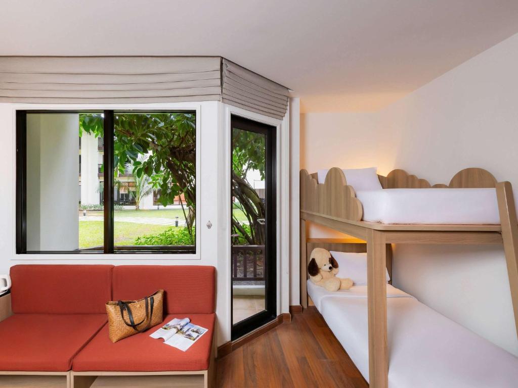 波普托Hotel Ibis Samui Bophut的客房设有双层床、沙发和窗户。