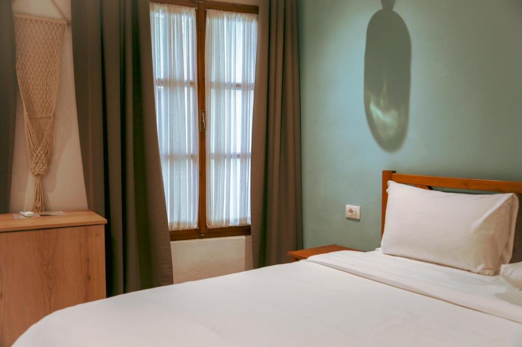 伏罗拉Agora Bed & Breakfast的卧室配有白色的床和窗户。
