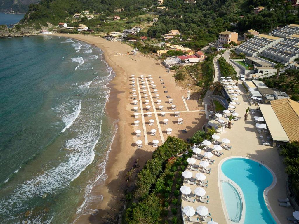 派莱卡斯Pelekas Monastery的享有海滩的空中景致,配有遮阳伞和海洋