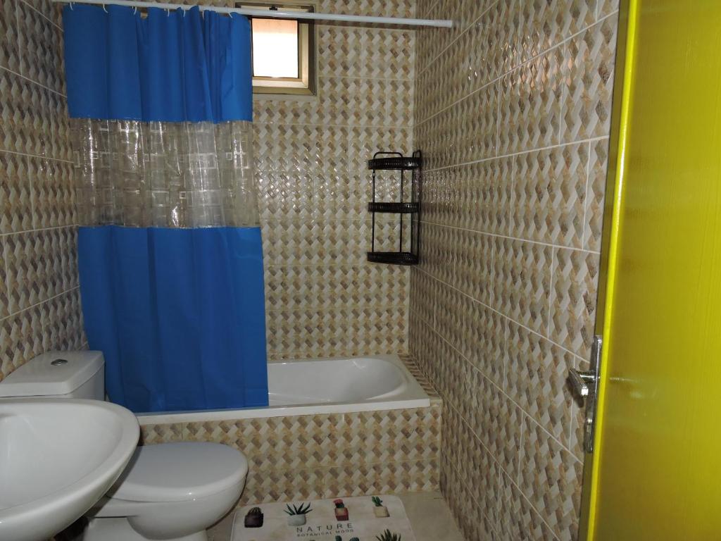 亚喀巴Mango haus的浴室配有卫生间、浴缸和水槽。