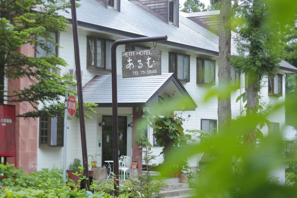 白马村HakubaGoryu Pension&LogCottage Arumu的白色房子前面的街道标志