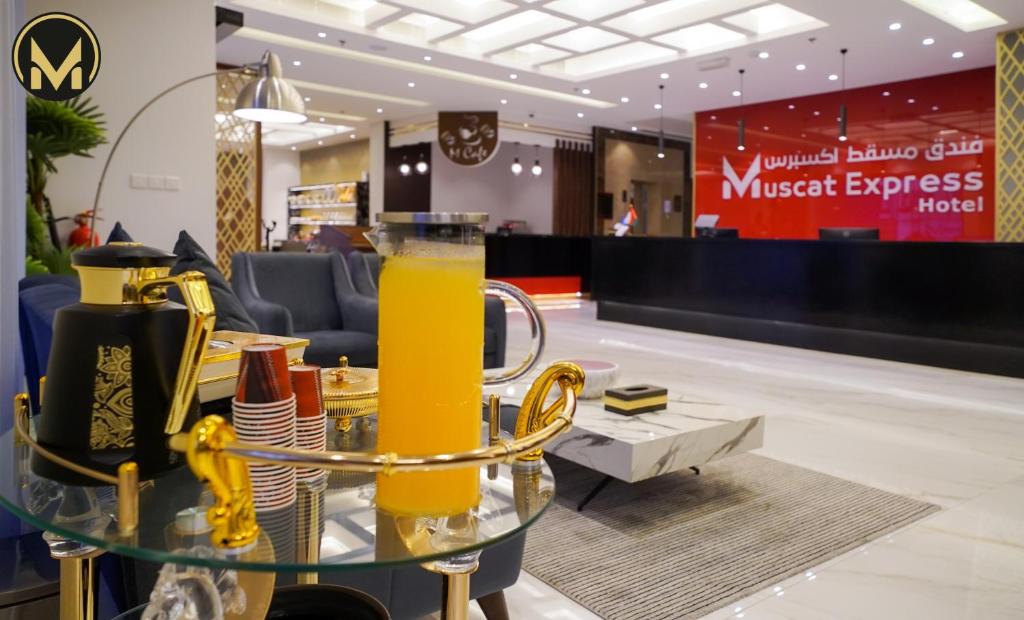 马斯喀特Muscat Express Hotel的大堂的玻璃桌,上面放着橙汁