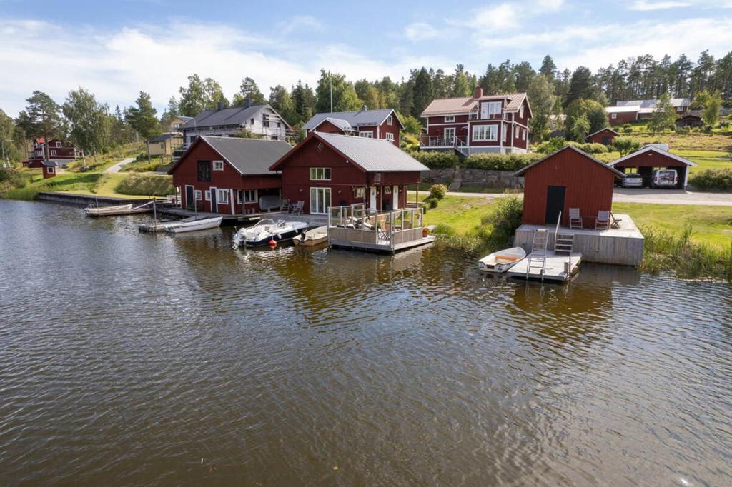 胡迪克斯瓦尔Seaside Cottage House nr 1, Saltvik Hudiksvall的湖水边的一群房子
