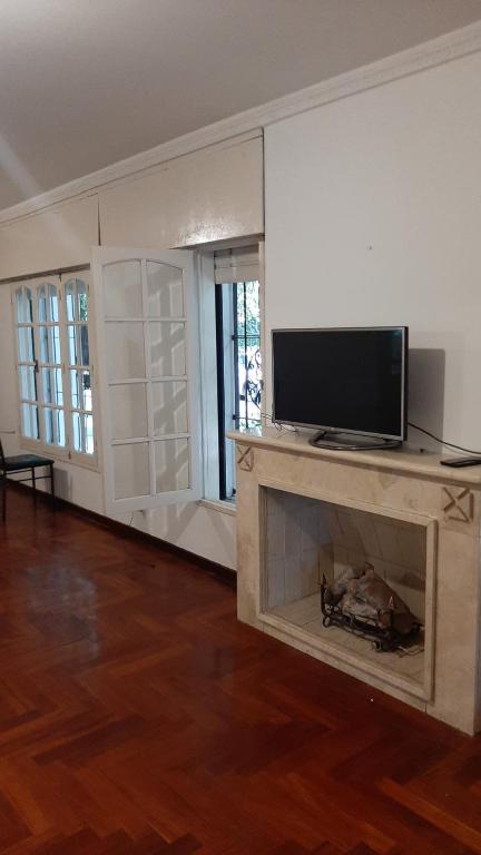 科尔多瓦Alojamiento Kempes的一间带电视和壁炉的客厅