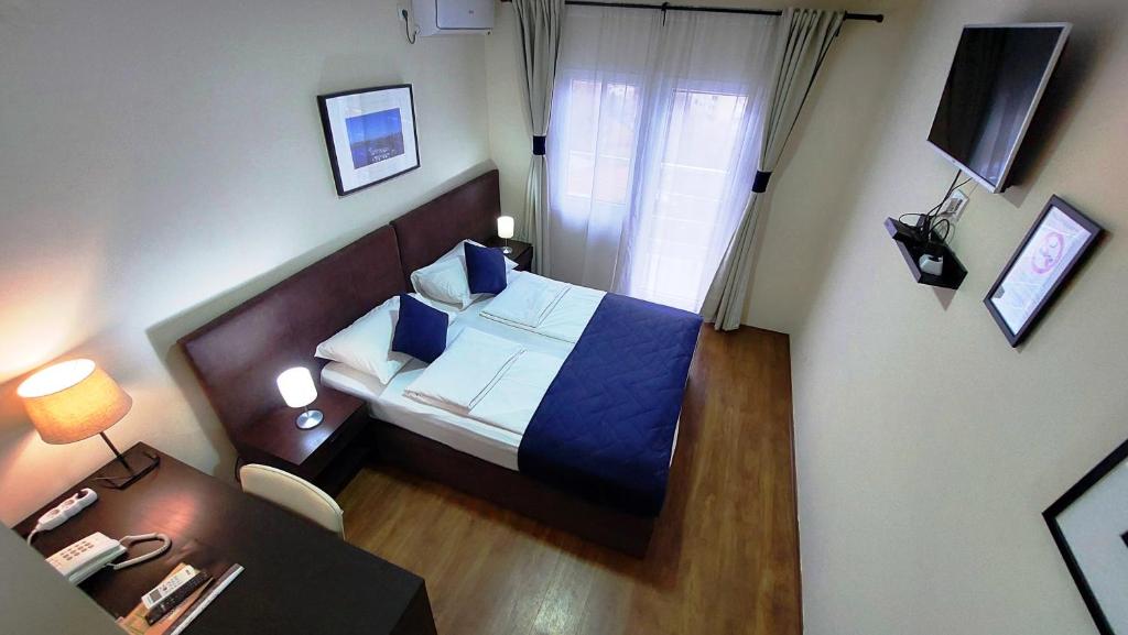 贝尔格莱德全景别墅酒店的小房间设有一张床和一张带电话的书桌
