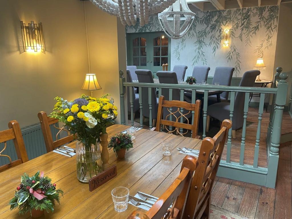 赛伦塞斯特The Golden Cross的用餐室配有带鲜花的木桌