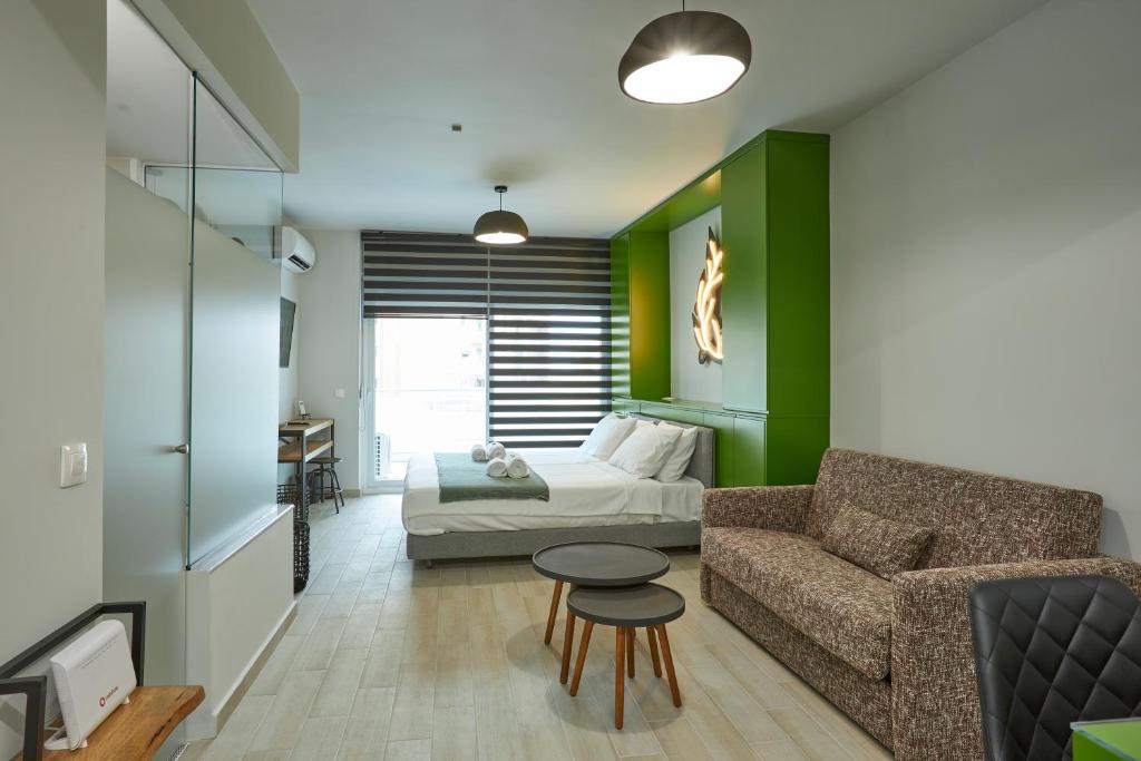 塞萨洛尼基Olea Apartments的客厅配有床、沙发和桌子