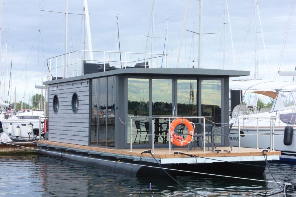 温德托尔夫Hausboot Fjord Lacerta mit Dachterrasse in Wendtorf的一条小船绑在水中的码头上