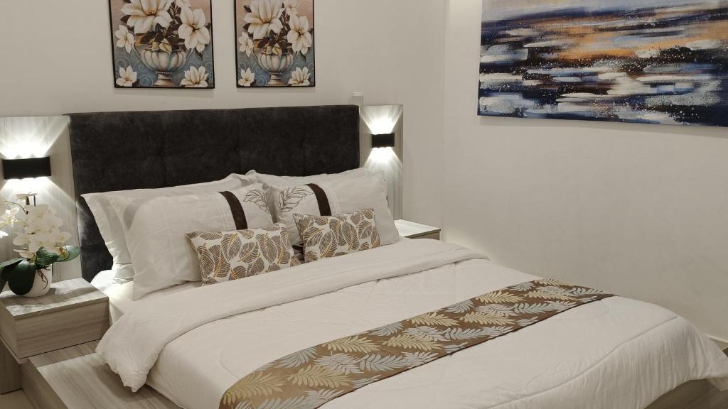 关丹Orchid Guesthouse Kuantan的卧室配有带枕头的大型白色床
