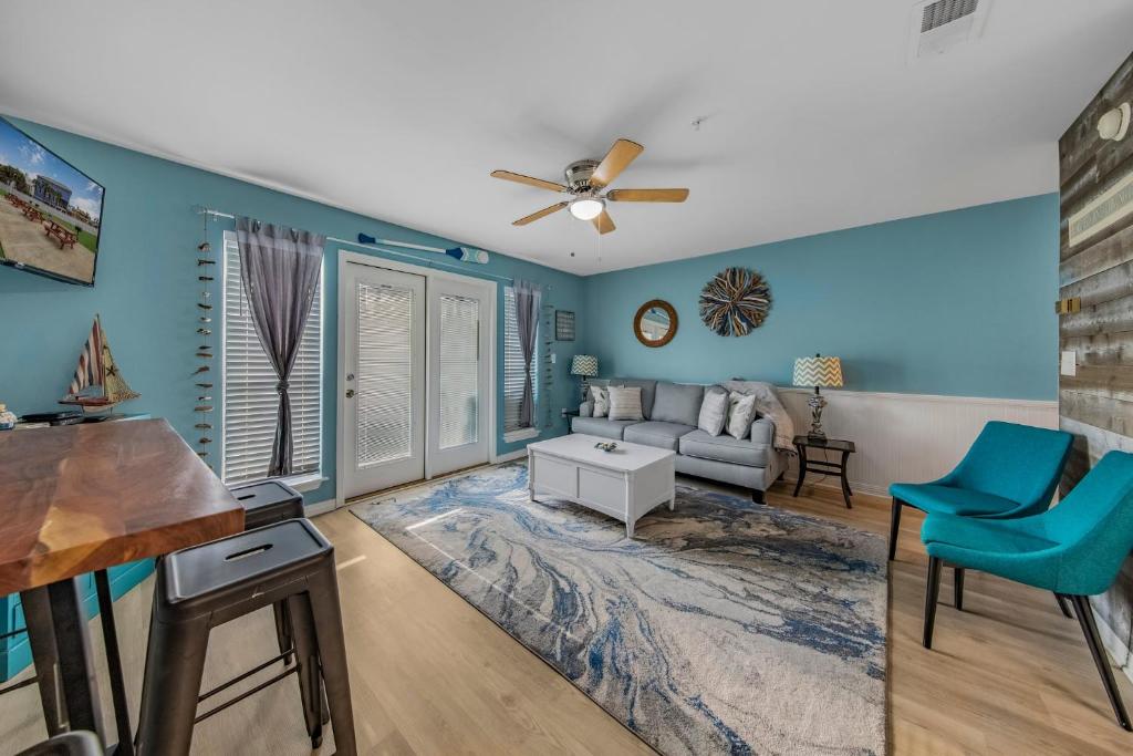 彭萨科拉Grand Caribbean in Perdido Key 111E by Vacation Homes Collection的客厅设有蓝色的墙壁和吊扇。