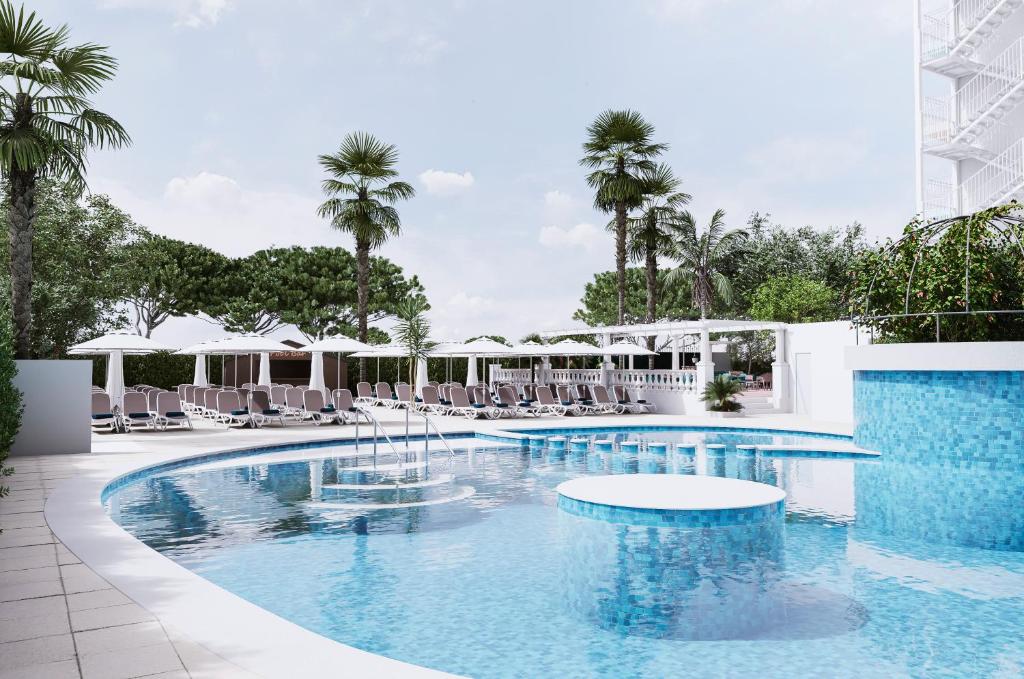 皮内达德马尔Bamblue Boutique Apartments的一个带椅子和棕榈树的度假村游泳池