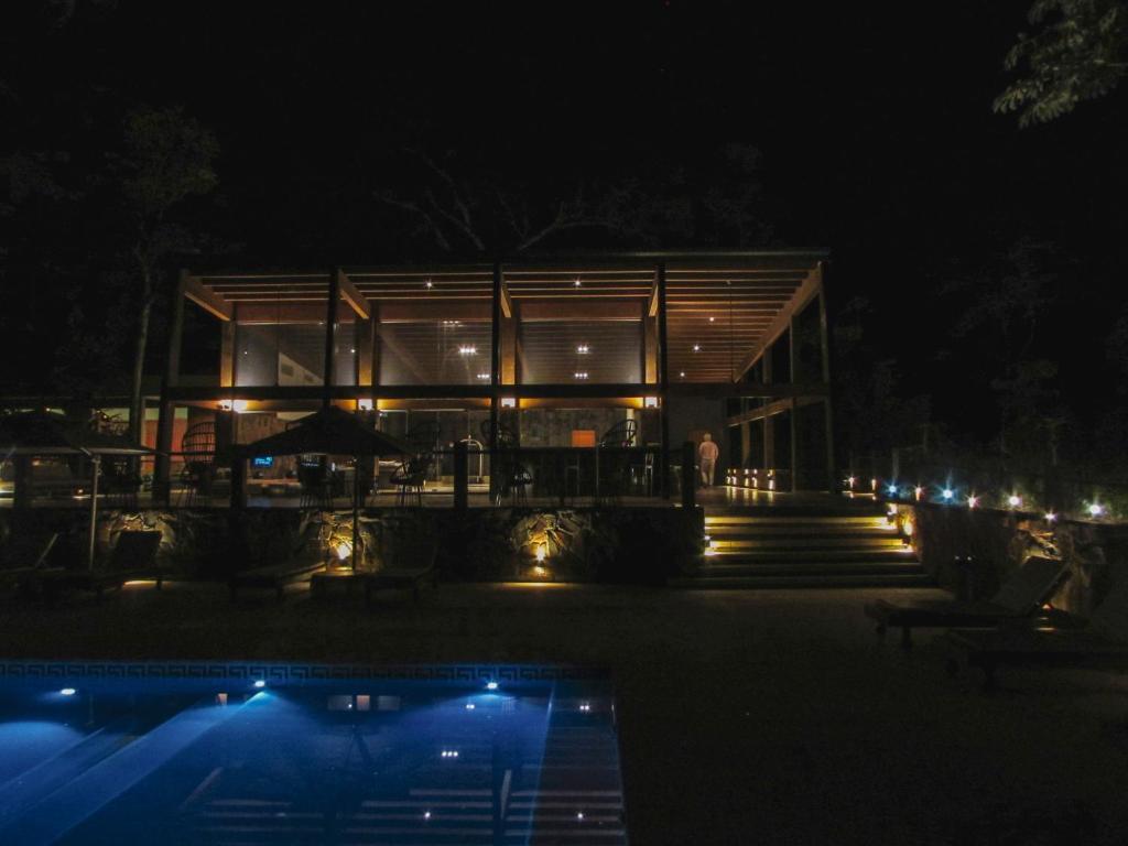 伊瓜苏港Selvaje Lodge Iguazu的一座晚上有游泳池的建筑