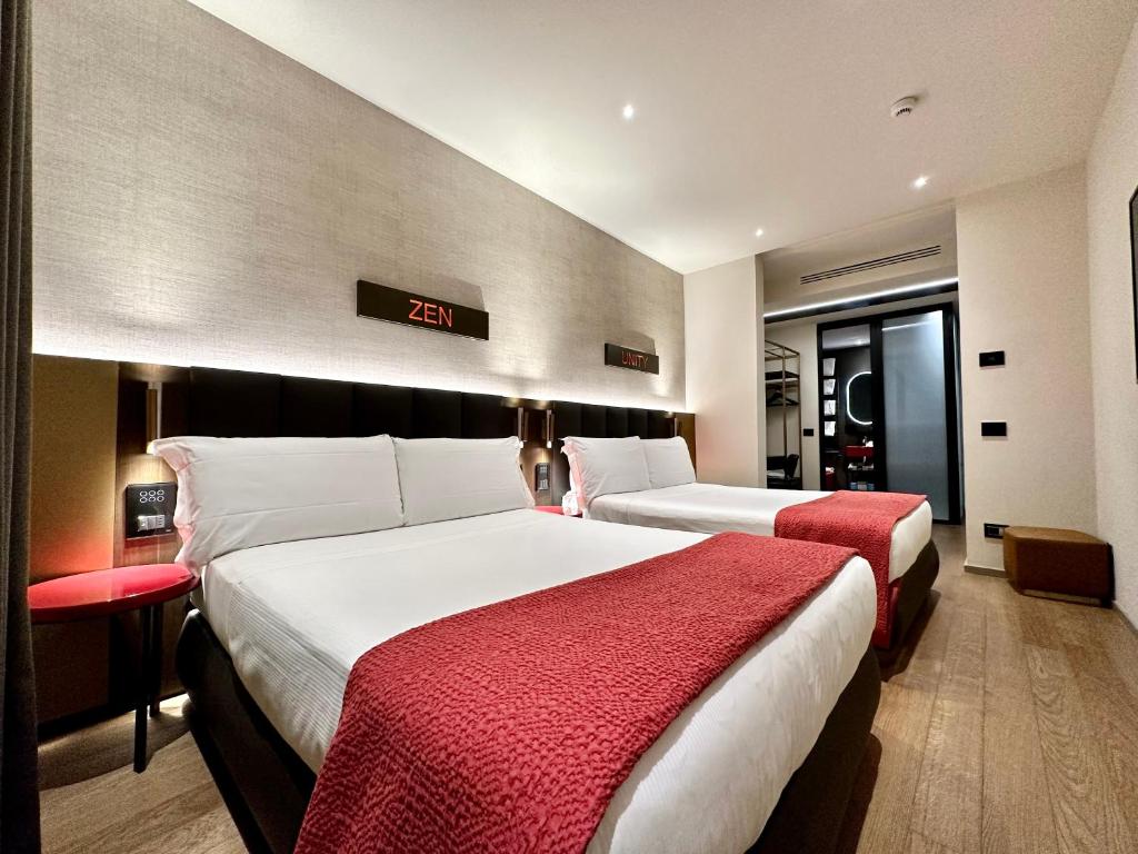 佛罗伦萨The Market Urban Hotel的酒店客房设有两张床和墙上的时钟。