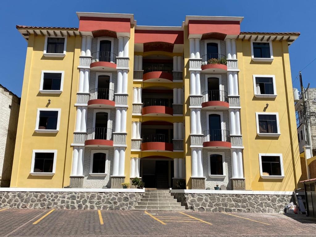 克萨尔特南戈Apartamento #2 Portal de Occidente的一座大型黄色建筑,位于街道上,设有阳台