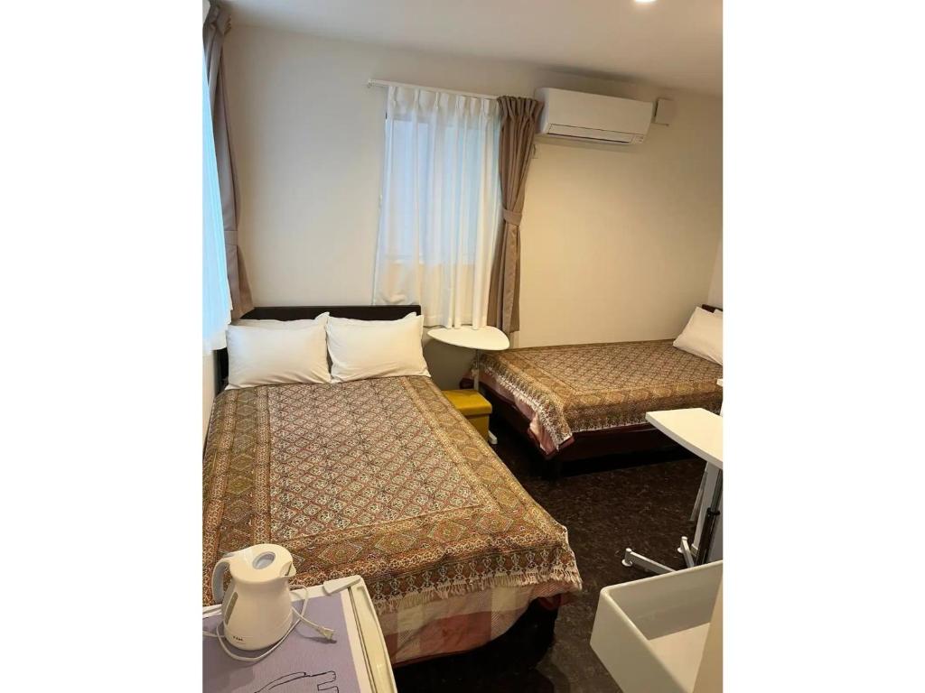 东京Tokyo stay Hut SARI - Vacation STAY 27239v的酒店客房设有两张床和窗户。