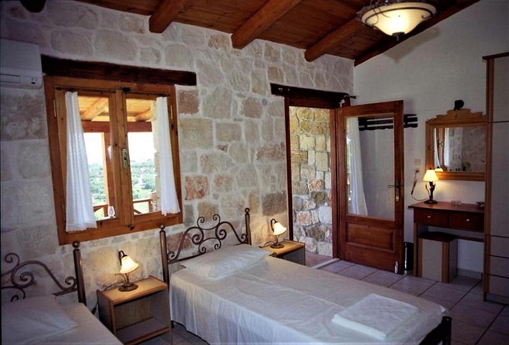 瓦西里科斯Villa Belvedere - Sea view apts near Banana beach的一间卧室设有两张床和两个窗户。