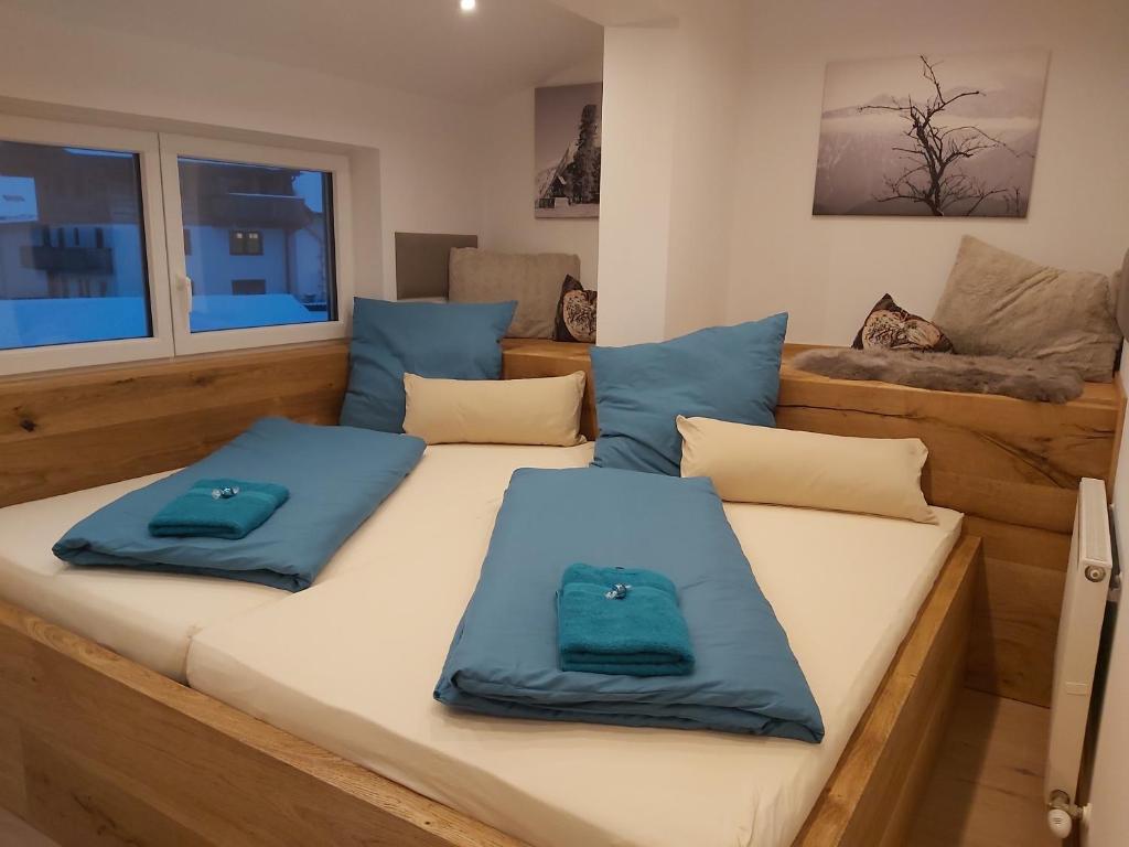 因斯布鲁克Penthouse-Feeling MaBeA的两个蓝色枕头坐在房间里的床边