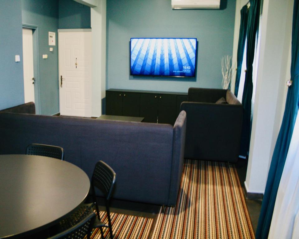 塞萨洛尼基REM House的客厅配有沙发和墙上的电视