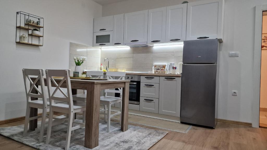 皮罗特Vila Harmony的厨房配有木桌和冰箱。