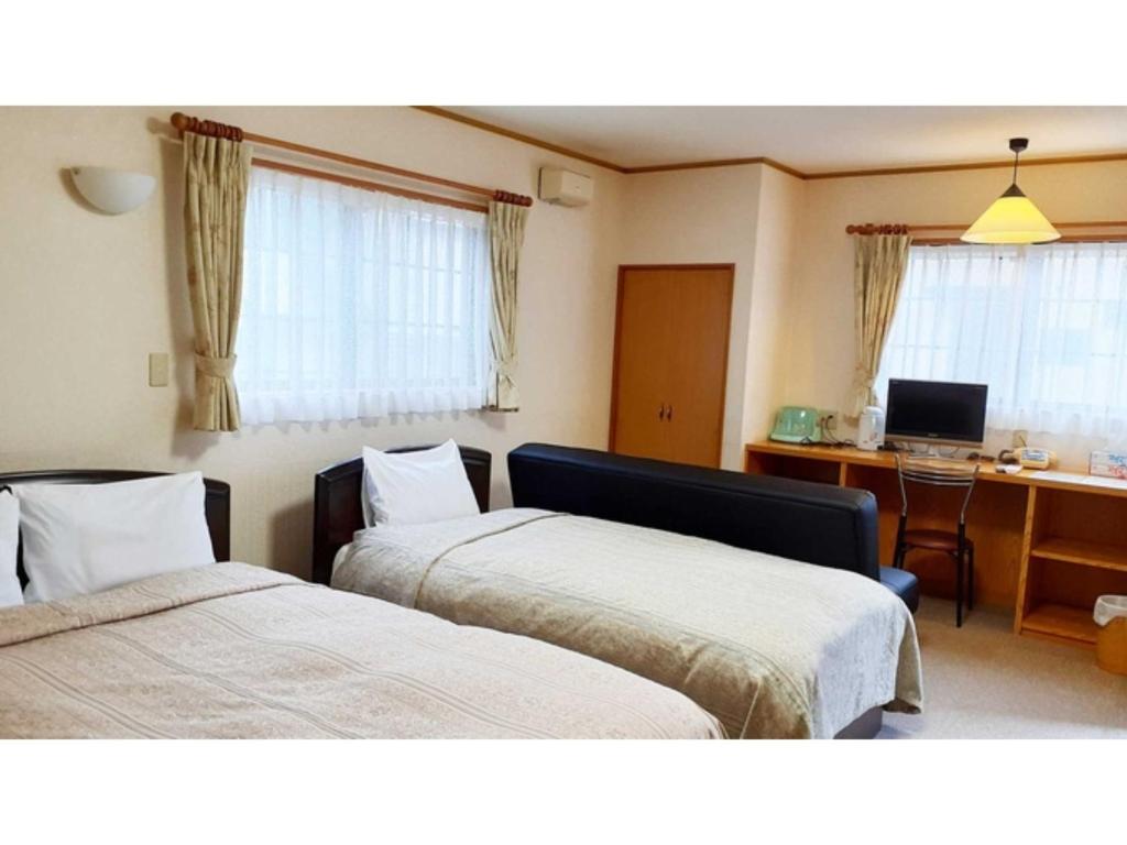 日光Sudomari no Yado Sunmore - Vacation STAY 46742v的客房设有两张床和一张带电脑的书桌