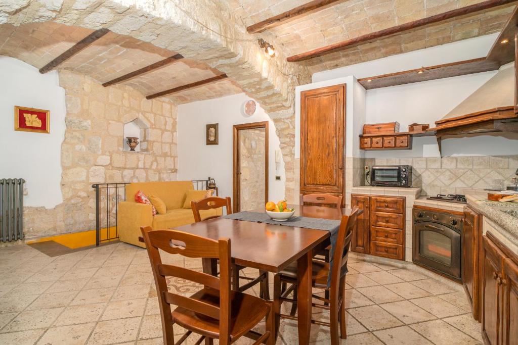 塔尔奎尼亚La Casa dell' Etrusco的厨房以及带桌椅的用餐室。