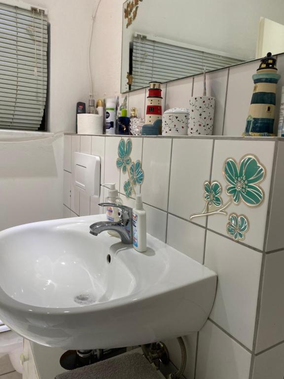 不莱梅Helles Appartment的浴室设有白色水槽和镜子