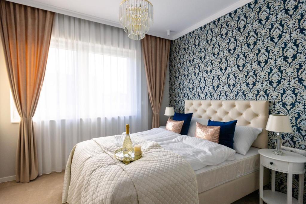 ZB Apartment Luxor Bobrowniki Rogożnik Pyrzowice的一间卧室配有一张大床和一个吊灯。