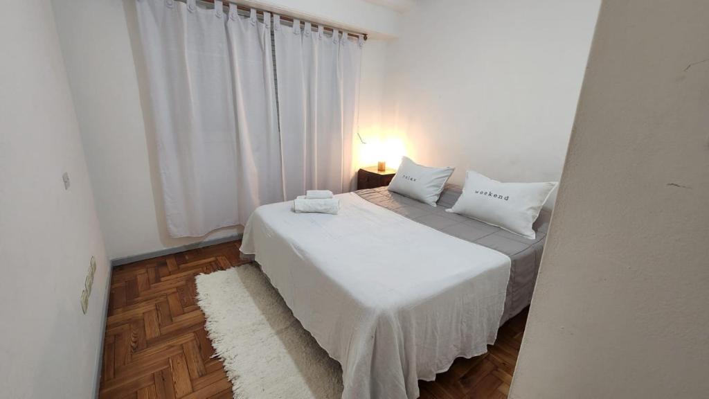 蒙特格兰德Casa Azcuénaga - Parque - Zona comercial - Aerop 15 min的一间卧室配有一张带白色床单的床和一扇窗户。