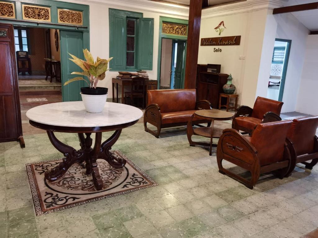 梭罗Ndalem Kinasih Homestay Syariah的客厅配有桌椅