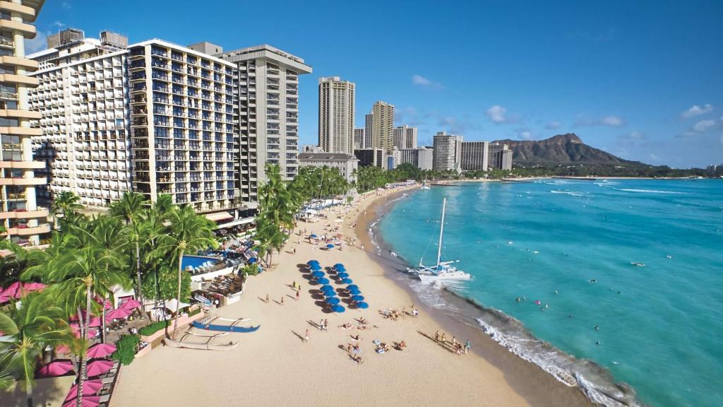 檀香山OUTRIGGER Waikiki Beach Resort的享有海滩的空中景色,拥有人员和建筑