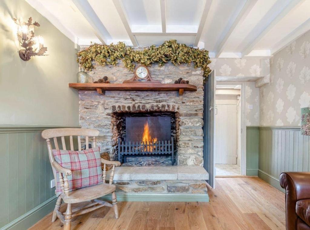 Bere AlstonRosemary Cottage的客厅设有石制壁炉和椅子