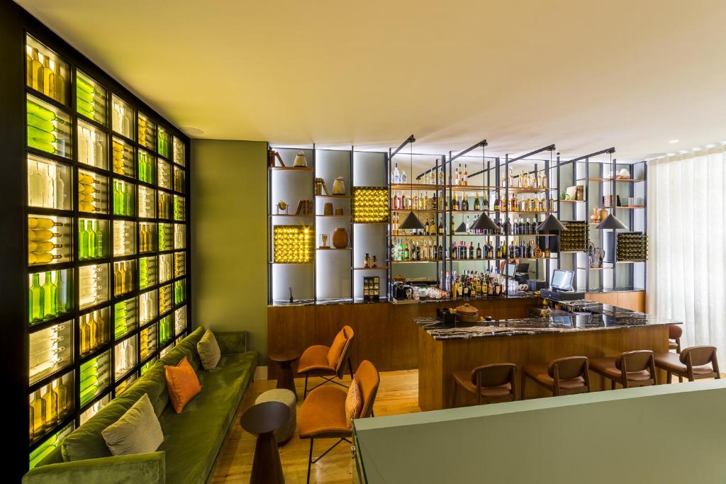 波尔图Gallery Hostel的餐厅的酒吧,有绿色的墙壁