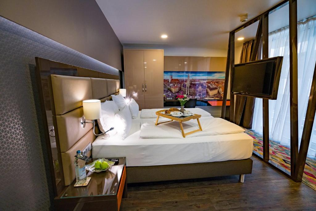 慕尼黑慕尼黑柯雷思公寓式酒店的酒店客房设有一张大床和一台电视。